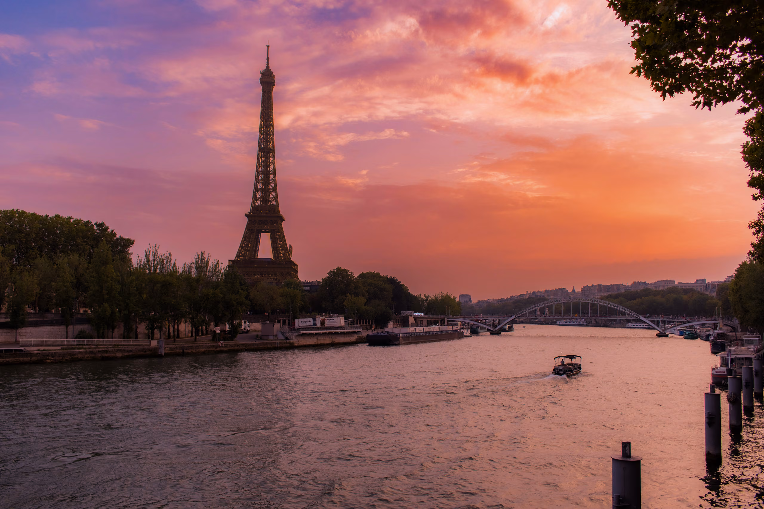 Torre Eiffel y el río Sena al atardecer, en París, ciudad que puede influir en el presupuesto de un viaje por Europa